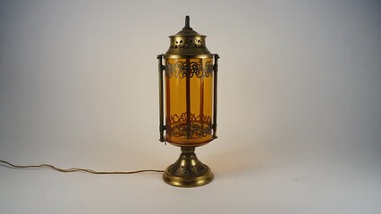 Fototapeta premium Antique brass table lamp with amber glass panels and decorative metal accents.