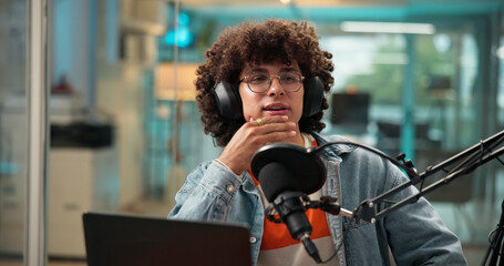 Man, talking and headphones with mic for broadcast, recording podcast and reporter in studio. Male...