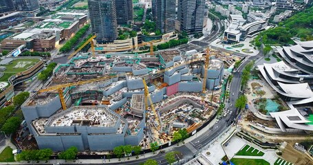 Aerial shot of a massive urban construction site with multiple tower cranes building the foundation of a modern commercial center. - Powered by Adobe