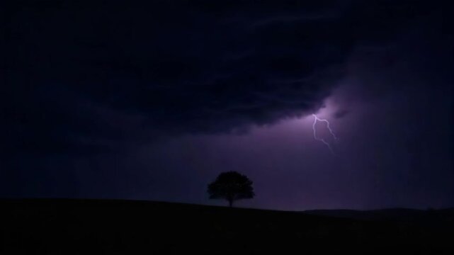 Dark stormy night with a lightning bolt striking behind a lone tree in silhouette.