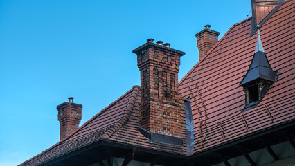 Old brick chimneys on historic buildings. Need for repair of damaged historic architecture.