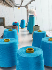 Yarn spools on a textile manufacturing production line