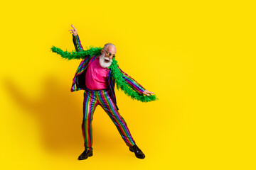 Photo of cheerful glad crazy man wear stylish striped bright suit cool entertainment isolated on yellow color background