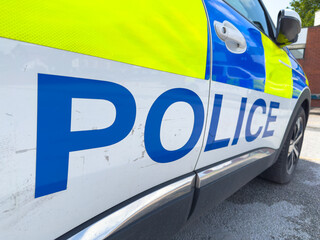 British police car with yellow and blue battenberg along the side the and the letters POLICE