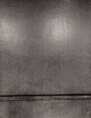 photograph of a slightly worn, dark-toned poster wall with subtle vertical seams and fine surface...