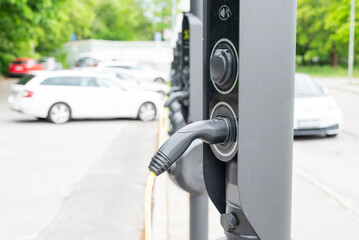 EV charger connected to a car during daytime. Sustainable mobility and green tech.