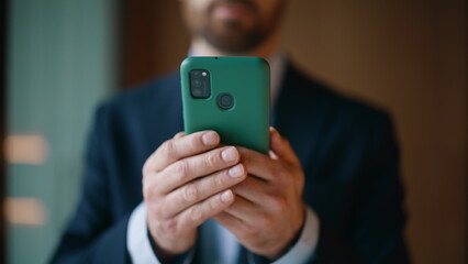 Executive hands holding mobile phone at company workspace closeup. Elegant man