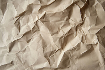 Obraz premium Crumpled brown paper texture showcasing unique patterns and natural folds in close-up detail
