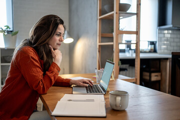 Focused entrepreneur working remotely from home office using laptop