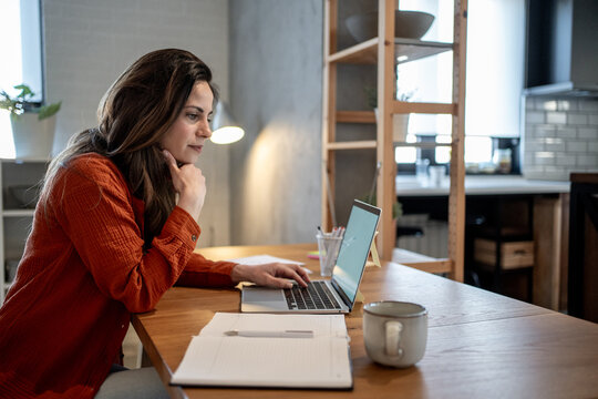 Focused entrepreneur working remotely from home office using laptop
