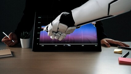A robotic hand shakes hands with a human as they analyze stock market trends on a digital screen,...