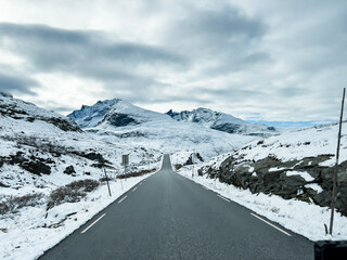 A winter landscape along the Sognefjellsvegen road in Norway, featuring snow-covered mountains and...