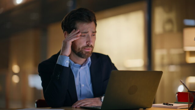 Tired specialist working computer at dark workspace under lamp light closeup. - Powered by Adobe