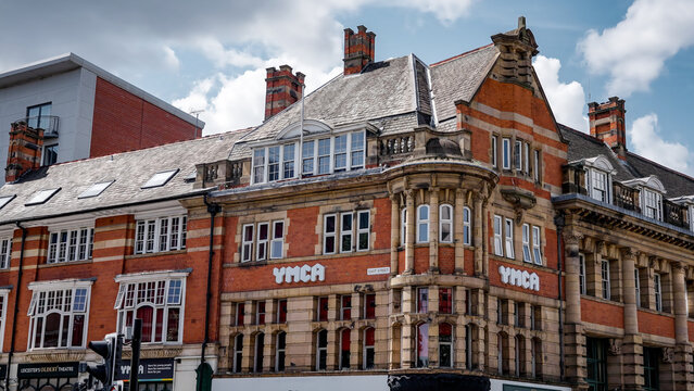 LEICESTER, UK - JUNE 14, 2025 - Red brick facade of YMCA building in Leicester, UK, featuring chimneys and windows on a cloudy day