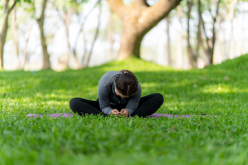 Woman Stretching in Butterfly Pose in Park