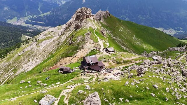 Aerial, forward drone flight near Rotwandh&uuml;tte ( Rifugio Roda di Va&egrave;l). Above alpine meadow with many rocks.  Impressive Dolomites, Italy. Wonderful hiking destination. Wild outdoor nature.