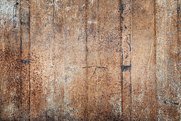 Abstract background. A close-up of a weathered, rusty metal surface. Grunge texture with peeling paint and rich brown-orange tones.