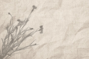 Soft shadow of wildflowers on light linen fabric. Natural delicate background.