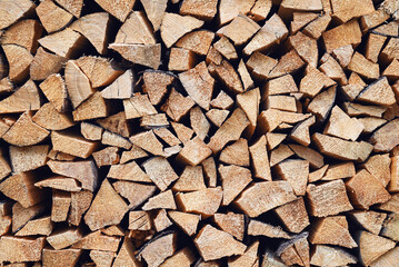 Log background. Dense texture of neatly stacked chopped firewood.