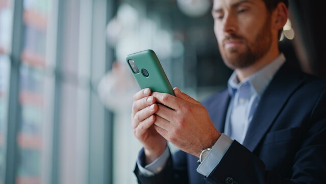 Confident lawyer browsing smartphone at office hall closeup. Serious businessman - Powered by Adobe