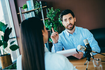 Two professionals collaborating in a modern workspace during an interview or work discussion at the...