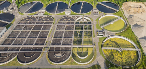 Eco-friendly aerial view of wastewater treatment plant near Lyon, France, with urban skyline – sustainable water management and environmental protection concept