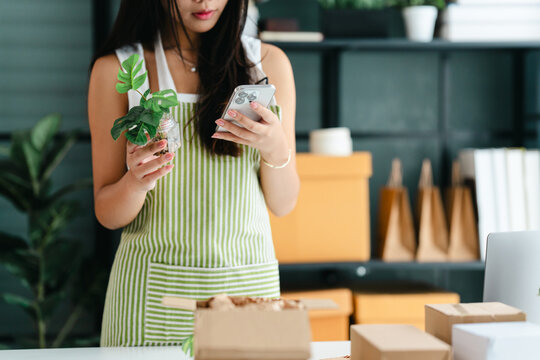 Female entrepreneur managing and packing online orders at home