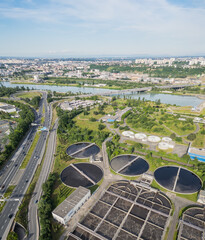 Eco-friendly aerial view of wastewater treatment plant near Lyon, France, with urban skyline – sustainable water management and environmental protection concept