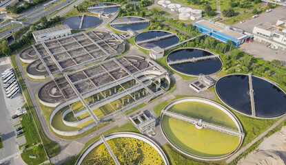 Eco-friendly aerial view of wastewater treatment plant near Lyon, France, with urban skyline –...