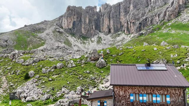 Aerial, forward drone flight near Rotwandh&uuml;tte ( Rifugio Roda di Va&egrave;l). Above alpine meadow with many rocks.  Impressive Dolomites, Italy. Wonderful hiking destination. Wild outdoor nature.