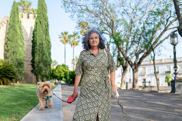Senior woman walking her dog outdoors