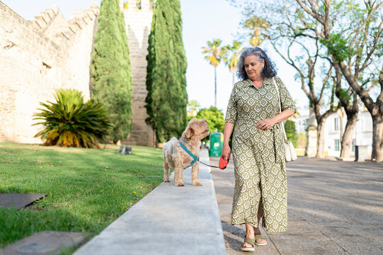 Senior woman walking her dog outdoors