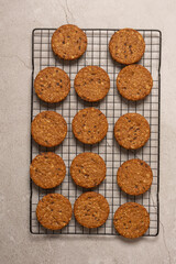 set of cookies cooling on a cooking rack, upside view. They are lying on a grey surface, and there is soft morning light.
