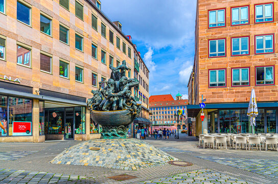 Nuremberg, Germany, July 15, 2024: Narrenschiff ship of fools fountain statue and colorful buildings in Old town Nuremberg city historical center, Middle Franconia region, Bavaria state