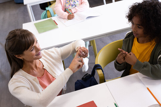 In school, female teacher using sign language with boy, fostering communication skills