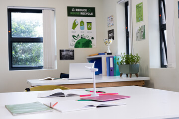 Classroom focusing on sustainability with wind turbine model and open notebooks, at school