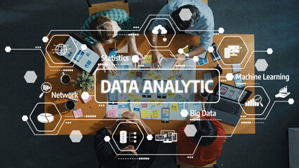 A diverse team collaborates over a data analytic project, surrounded by technology icons and charts, fostering creativity and innovation in a modern workspace setting. Amity