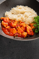 Chicken curry rice butter chicken tikka masala spicy meat bowl on the table fresh tasty gourmet food background on rustic food top view copy space