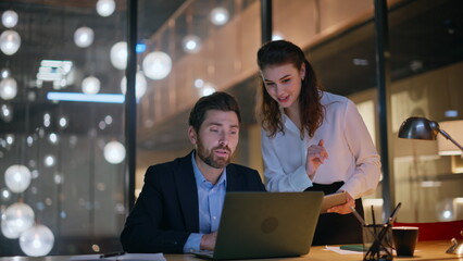 Friendly colleagues talking virtual meeting at evening creative agency office. 