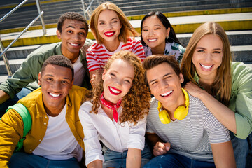 Friendly cheerful friends enjoying summer outdoors on a staircase