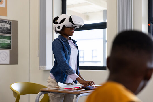 Girl using VR headset in classroom, exploring virtual reality technology, at school