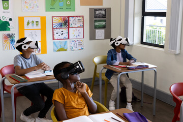 Diverse students in classroom using VR headsets for interactive learning experience, at school