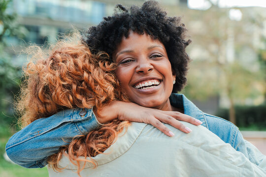 Two women experiencing a joyful moment as they share a heartfelt embrace filled with warmth and genuine happiness, showcasing the beauty of friendship and connection in their lives.