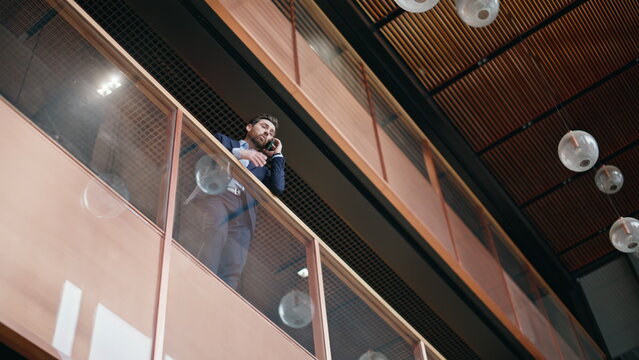 Entrepreneur calling glass balcony business center bottom view. Manager talking