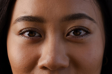 Expressing confidence and focus, close-up of Asian woman's eyes in school setting, at home