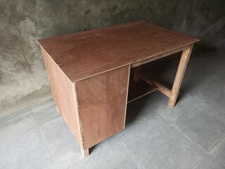 Simple Wooden Desk Against Industrial Concrete Wall