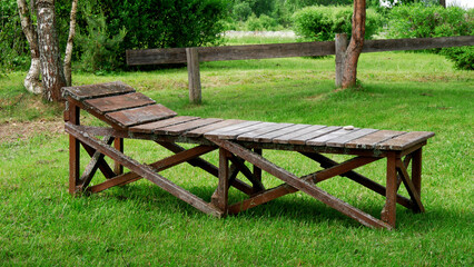 Wooden sunbed on the grass