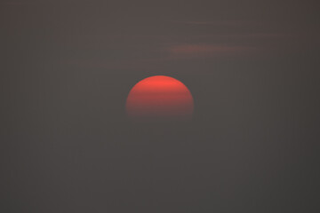 Sunset casting a warm glow over the horizon with clouds enhancing the vibrant colors and...