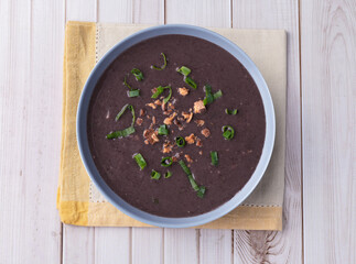 Black bean soup in a bowl over wooden table