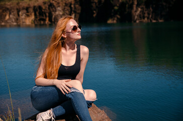 young woman sitting by the lake